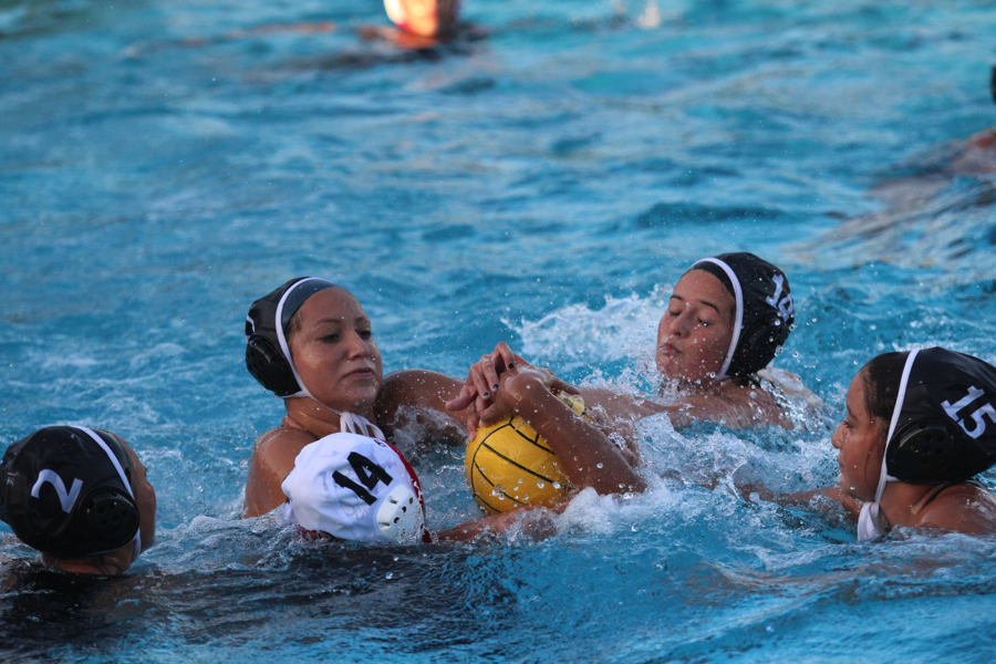 A lose ball of a counter attack sends Olivia Aguirre, 11, Alex Perez, 10, and Meghan Nevarez, 12, to try to regain possession of the ball as they take on the Whittier High School Cardinals in the Downey Aquatics Center on Dec. 11. The lady vikes kept their winning strike, as the final score was 11-9.