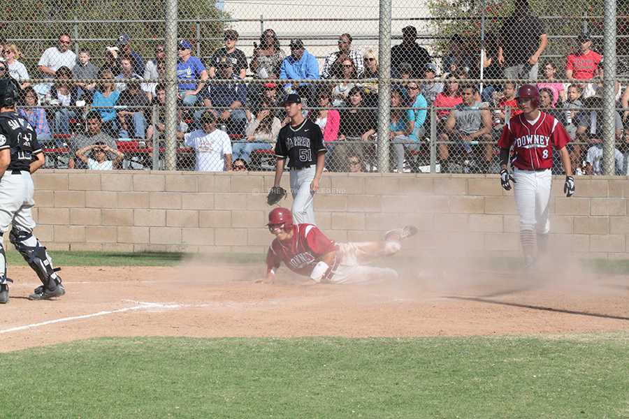 At the Downey baseball field, Ernest Davila slides into and over the home plate against crosstown rival Warren on Friday, April 12, to gain a point against the Bears. Davila’s slip into safety and home plate was not enough to secure a victory for the Vikings.