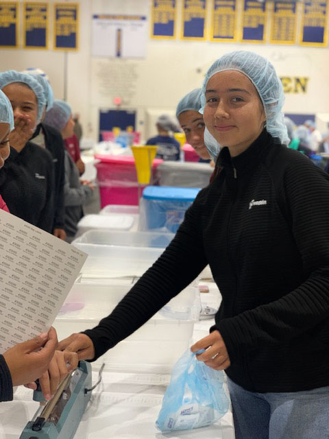 Giving back to her community alongside her lacrosse teammates, Mariana Garcia , 9, helps pack boxes of food for the homeless on April 5. “It’s important to attend events like this as a team because it brings us all closer together,” Garcia said. “We get to learn more about each other and do something good for our community at the same time.” 