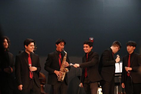 Angel Cazachkoff is shown holding the microphone for Ezekiel Leyva as he performs a solo on the alto saxophone at the annual fall jazz concert on October 26, 2022 at the Downey High School theater.